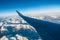 Looking through the window aircraft during flight a snow covered Italian and Osterreich Alps with blue sky without clouds