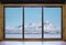 Looking through window in winter, wooden window frame with desk and landscape snow mountain and frozen lake view in Iceland