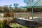 Lookout with metal roofed gazebo with ridges and texture on surface in shade with handrails and cement walkway in sun