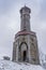 Lookout tower Stepanka on the border of Krkonose and Jizera Mountains. Winter overcast day, sky with clouds, trees