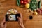 Looks good. Top view of hands of man, cook taking picture of garlic butter shrimp pasta, meal decorated with basil and