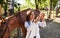 Looks at syringe. Female vet examining horse outdoors at the farm at daytime