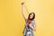 Looks tired. Half-length portrait of young girl, correspondent holding reporter microphone isolated on yellow studio