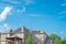 Lookup view covered patio two story suburban residential house with black solar panels installation on shingle roofing sunny cloud