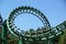 Loop and turn on a green roller coaster in an amusement park