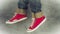 Loopable Stop Motion Animation of Young Person in Jeans and Red Sneakers Walking