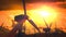 Looping animation of silhouettes of wind turbines at sunset