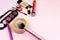 Loose face powder, brush and various cosmetic decorative makeup products on a pink background. Close up. Makeup brush and