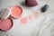 Loose rouge make-up powder with blender sponge on marble beauty table