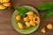 Loquat fruit. Nispero. Eriobotrya Japonica. Loquat in plate with fresh leaves on wood background