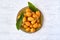 Loquat fruit. Nispero. Eriobotrya Japonica. Loquat in plate with fresh leaves on wood background