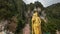 Lord Murugan Hindu Deity Statue at Batu Caves with Blue Sky and Moving Clouds in Malaysia Time Lapse