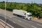 Lorry carrying refrigerated shipping container in motion on British motorway M25