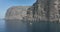 Los Gigantes steep huge cliffs rock wall bordering the blue atlantic ocean panorama seascape aerial drone footage