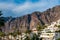 Los Gigantes village. Palm trees and white apartment houses in front of big rocks. Holiday destination near Pico del Teide
