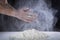 Ð¡lose up of chef human`s hands preparing for kneading the dough on the table, powdering with flour. Making dough by hands at