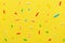 Ñlose up of colorful sprinkles over yellow background, decoration for festive Valentines day, birthday, holiday and party time