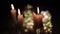Ð¡lose-up of several candles that burn with flickering glare. Close shot of candles in a dark room with a blinking