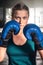 Ð¡lose up view of girl in boxing gloves training at gym. Young woman boxing in the gym