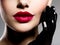 Ð¡lose-up women`s lips with red lipstick and black gloves on cheek