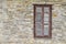 Ð¡losed brown shuttered window in the wall of the light artificial stone