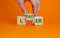 From loser to leader symbol. Businessman turns wooden cubes and changes the word `loser` to `leader`. Beautiful orange backgro