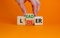 From loser to leader symbol. Businessman turns wooden cubes and changes the word `loser` to `leader`. Beautiful orange backgro