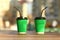 Ð¡loseup of green paper coffee cups on the outdoor wooden surface, place for logo, straws looking different direction