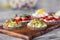 Ð¡loseup macro set of different northern trendy appetizers on smorrebrod rye bread with red caviar and avocado, strawberries,