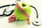 Losing weight - green apple, measuring tape and stethoscope