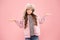 At a loss. warm clothes for cold season. fur hat accessory. small girl winter earflap hat. bewildered child pink