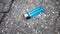 Lost blue cigarette lighter at the asphalt