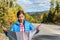 Lost travel tourist woman searching for directions on map on road trip in nature fall autumn outdoors. Funny Asian girl making