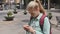 Lost woman checking map on smartphone walking in the city