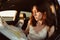 Lost young woman sitting in her car in the countryside and looking at map