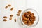 A lot of almonds in glass containers, on a light wooden background.