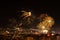 A lot of bright fireworks in the night sky over a city. Townspeople launching fireworks during  the New Year celebrating at