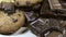 Lot of chip cake cookies with chocolate close-up tilting and Pieces of milk and dark chocolate