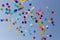 A lot of colorful balloons flying away in clear blue sky