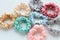 Lot of Colorful silk Scrunchies on white. Flat lay Hairdressing tools and accessories. Hair Scrunchies, Elastic HairBands, Bobble