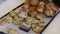 Lot of cooked appetizing cakes, buns and roll with poppy seeds on kitchen tray closeup