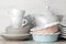 A lot of different dishes. Dinnerware. on a light concrete background. dishes for serving the table. various plates, bowls, and cu