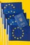 A lot of european union flags and a blue passport of ukraine, on a yellow background