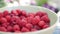 A lot of fresh raspberries in rotating bowl. Closeup