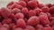 A lot of fresh raspberries in rotating bowl. Closeup