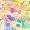 A lot of full spectrum multi pastel colored clothing plastic buttons randomly scattered on the gray background - top view