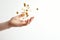 A lot of gold coins fall into a man\\\'s hand on a white background. Generative ai