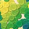 Lot of green, yellow and blue colored vintage clothing plastic buttons randomly scattered on the woody background - top view