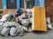 A lot of household, construction waste in bags. Old cabinet. Against a brick wall with peeling paint