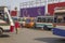 A lot of Indian bright multi-colored buses parked at the bus station on the background of people